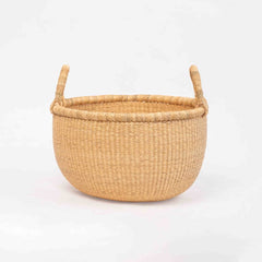 Handwoven round Bolga market basket with leather-wrapped handle, made in Ghana
