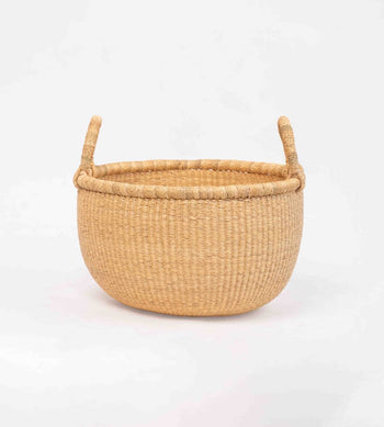 Handwoven round Bolga market basket with leather-wrapped handle, made in Ghana